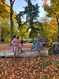 The Blossom Swing Dress in pink Ankara print, autumn park setting